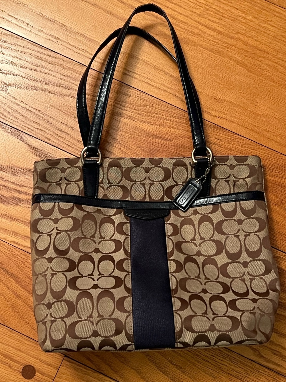 Coach monogram logo canvas shoulder handbag with blue trim and handles